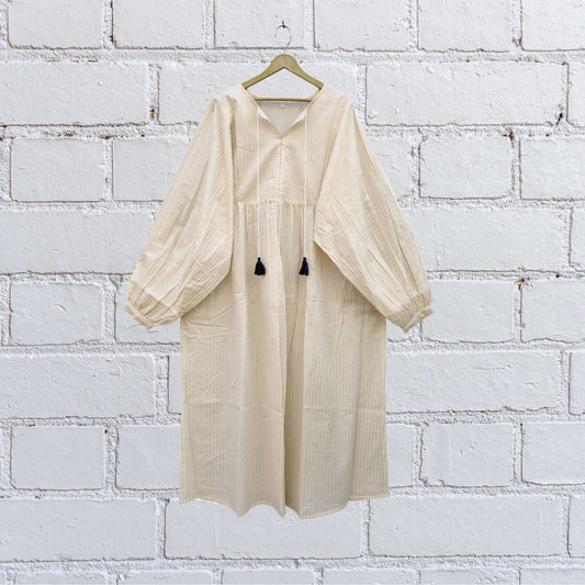 Boho midi dress featuring textured floral weave, puff sleeves, and tassel tie neck in ivory.